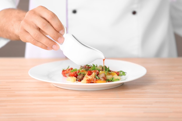 Kucharz przekładający potrawę na talerz